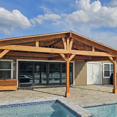 Forever Porch Pavilion (Options: 12' L x 25' W, Douglas-fir, 3-Post Anchor Kit for High-Wind, Electrical Wiring Trim for All Posts, 9 ft Posts Height, 2 Fascia Boards, No Post Decorative Trims, 2 Ceiling Fan Bases, No Curtain Rods, No Privacy Panels, Transparent Premium Sealant). Photo Courtesy of B. Carman of Ormond Beach, FL.